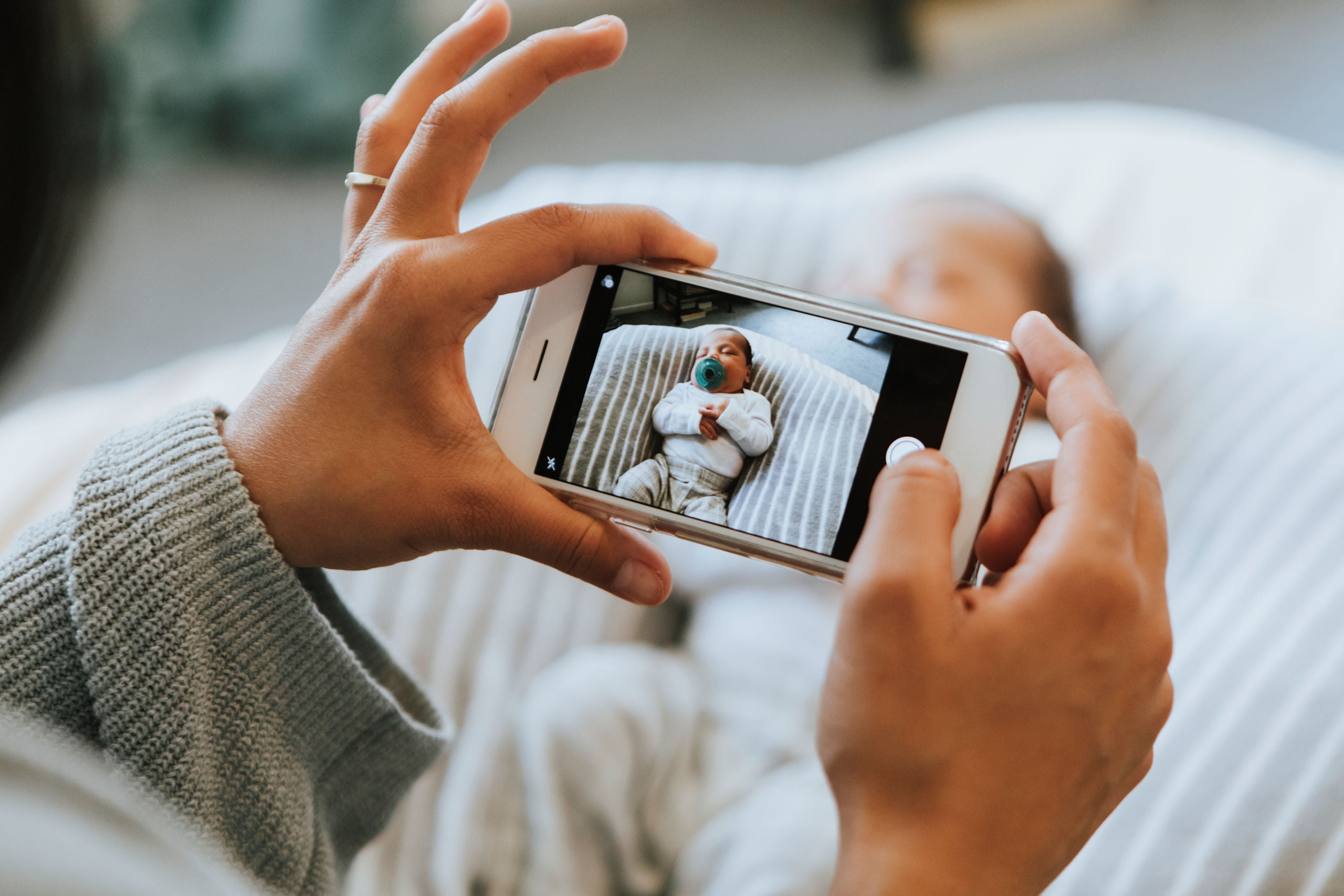 Matka robi smartfonem zdjęcie swojego nowonarodzonego dziecka