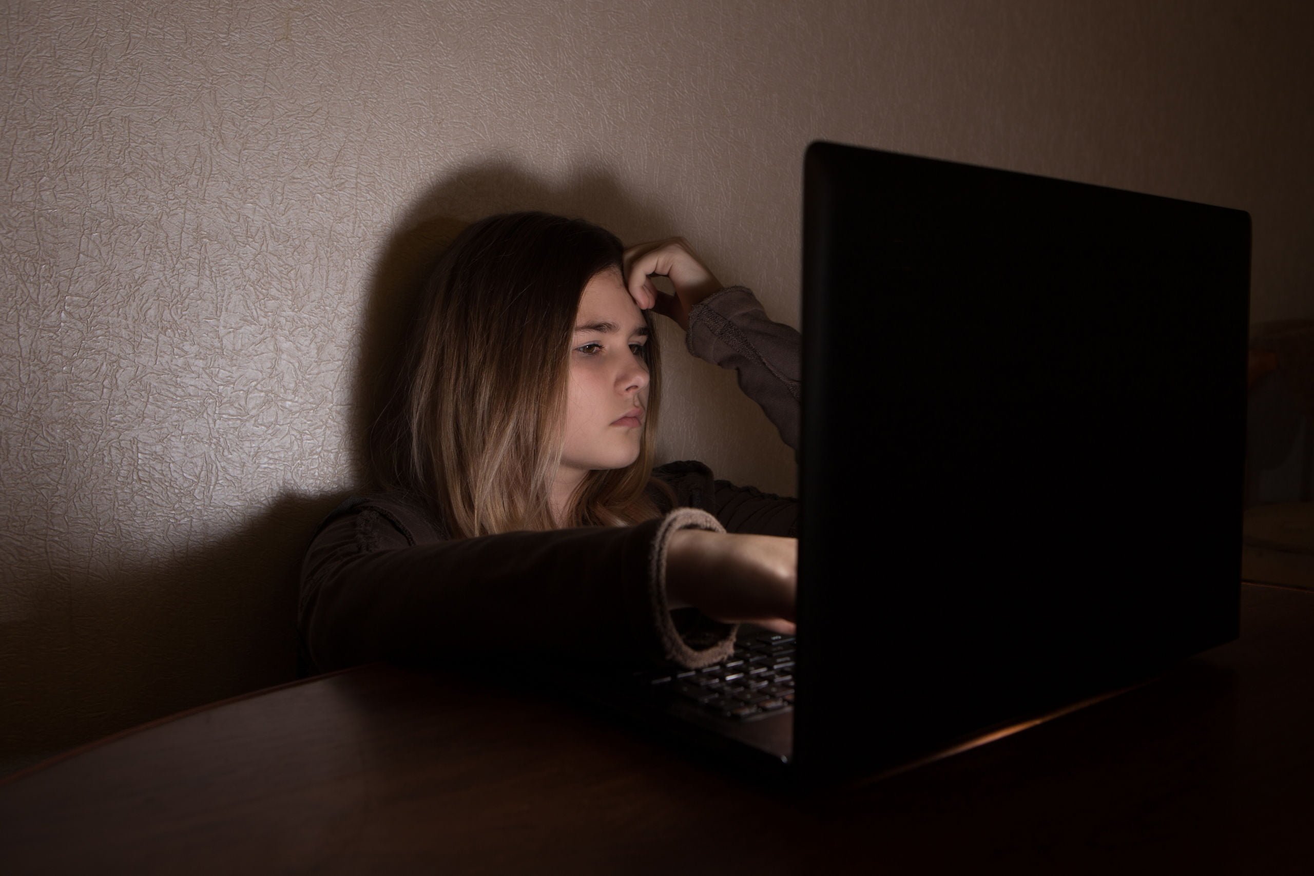 Nastoletnia ofiara cyberprzemocy przegląda internet